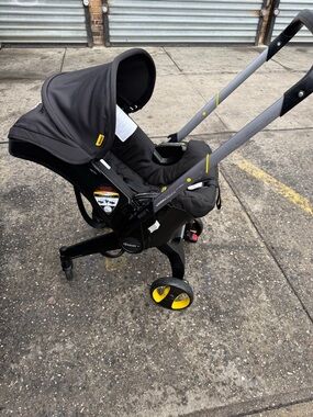 Doona Black Infant Car Seat Carrier / stroller with Yellow Accents